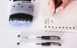 Gros plan de recharges de stylos gel noir écrivant sur un carnet de notes