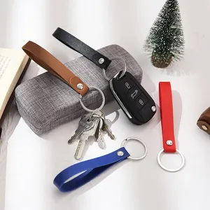 Handmade colorful leather strap keychains for car and home keys displayed on a white desk