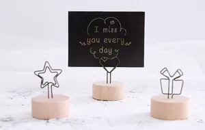 Close-up of vintage wooden message clip holders with heart and star wire shapes