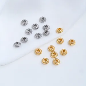 Dettaglio di perline distanziatrici in acciaio inossidabile oro e argento per gioielli.