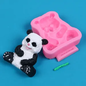 Detailed view of pink panda silicone mold alongside a finished black and white resin panda