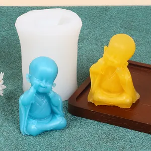 Silicone mold showing a detailed happy little monk figurine with finished gypsum samples