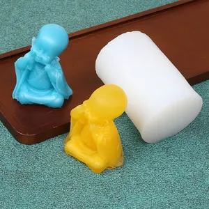 Detailed view of a DIY silicone mold next to blue and yellow happy monk wax candles.