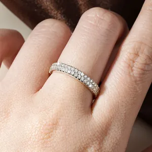 Nahaufnahme eines glitzernden Moissanit-Pave-Ringes am Finger für einen modischen Lagen-Look