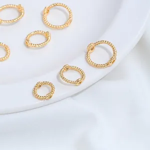 Détail macro de haute qualité d'anneaux de perles torsadés en acier inoxydable doré pour bijoux