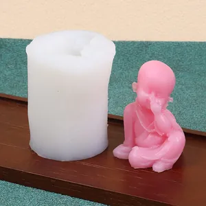 Macro detail of cylindrical silicone mold and finished pink little monk figurine for DIY