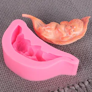 Detail of a silicone baby in hammock mold with a finished pink fondant baby figure.
