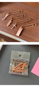 Juego de marcapáginas de metal oro rosa con dijes de flecha, pluma, cruz y regla.