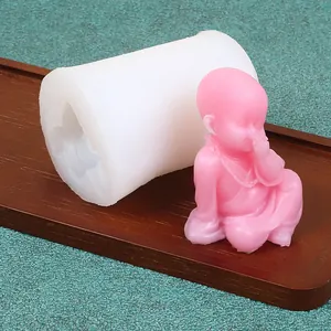 Silicone mold with finished pink little monk figurine for DIY scented candle making