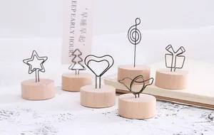 Close-up detail of various creative wire memo clips featuring round natural wooden bases