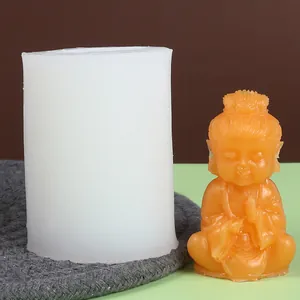 Silicone mold shown next to a finished orange wax monk ornament for DIY candle crafting