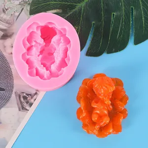 Detailed view of a pink silicone baby mold and an orange finished fondant figure
