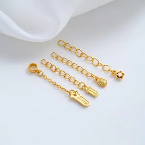 Detail view of 24K gold-plated jewelry extender chains with flower and lucky charms