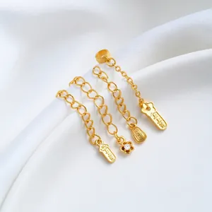Detailed view of 24K gold-plated extension chains with zircon flower and charms