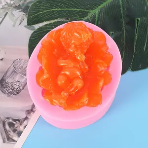Close-up detail of a pink baby-shaped silicone mold with an orange resin figure inside