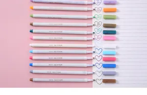 Primer plano de 12 marcadores metálicos con muestras de tinta de colores en corazón.