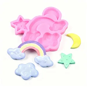 Dettaglio dello stampo in silicone con manufatti in argilla di arcobaleno, stella e luna