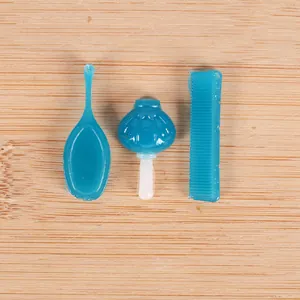 Detailed view of miniature blue resin comb mirror and bottle for DIY cake decoration