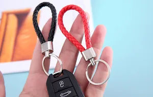 Detailed close-up of black and red braided leather keychain straps held by hand
