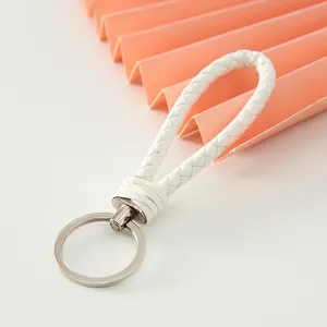 Close-up view of a minimalist white braided leather keychain strap with metal ring