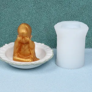 Detailed view showing a DIY little monk silicone mold beside a finished gold ornament