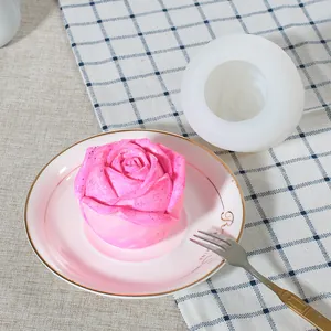 Detail view of rose silicone mold and finished pink flower candle or soap on a plate.