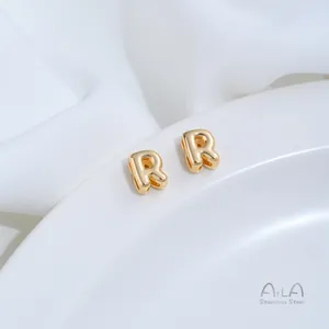 Nahaufnahme von zwei goldenen Buchstaben R Abstandsperlen aus rostfreiem Stahl für DIY Schmuck