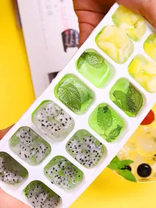 Detalle de cubitera de silicona de 14 rejillas con cubitos de fruta y menta