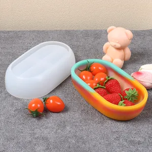 Dettaglio dello stampo in silicone a barca ovale e della ciotola colorata in resina finita