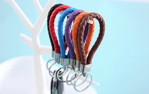 Macro shot of colorful braided leather keychain lanyards on a white display stand.
