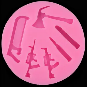 Vue détaillée du moule en silicone rose avec formes d'outils et de fusils pour gâteaux.