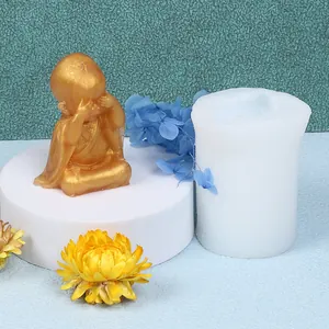 Detail showing a white silicone mold and its finished golden little monk plaster ornament