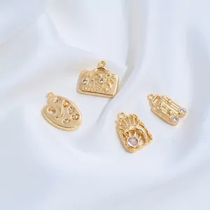 Detail view of 14K gold plated travel-themed charms including suitcase for DIY jewelry making.