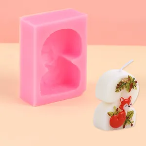 Close-up detail of a pink silicone mold and a finished number 2 candle with fox motif