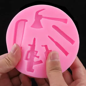 Détail du moule en silicone rose avec des formes d'outils et silhouettes de fusils