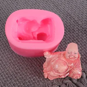 Detailed view of a pink silicone mold with a finished laughing Buddha plaster figure