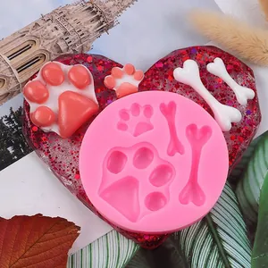Nahaufnahme einer rosa Silikonform mit niedlichen Pfotenabdrücken und Hundeknochenformen