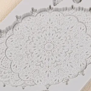 Vista dettagliata di uno stampo in silicone grigio con motivi floreali vintage per decorazioni.
