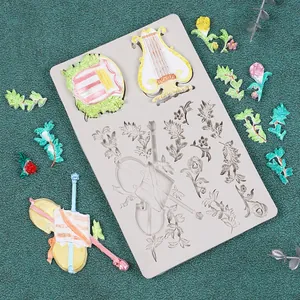 Dettaglio dello stampo in silicone per strumenti musicali con esempi di fondente colorato.