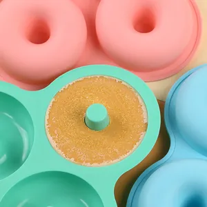 Detail view of a green silicone donut mold with a freshly baked golden cake inside