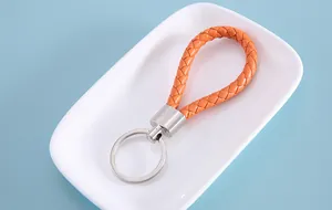 Detailed macro view of vibrant orange braided leather keychain with polished silver ring