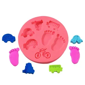 Detail of pink silicone mold with baby-themed cavities like cars and feet.