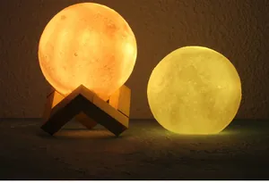 Close-up of dual 3D moon night lamps with warm soft glow and rustic wooden stand
