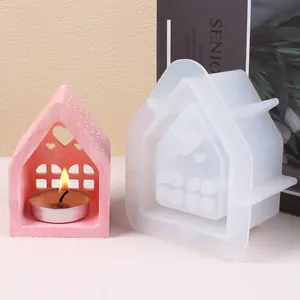 Molde de silicona con forma de casa para velas DIY mostrado con portavelas de yeso rosa