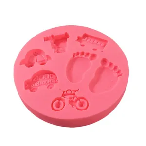 Close-up detail of a pink silicone mold featuring baby footprints and school bus shapes