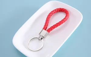 Detailed view of red braided leather keychain on a white decorative tray.