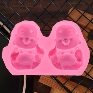 Detailed macro view of a pink silicone mold featuring two laughing monk character designs.