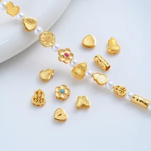 Close-up of 24K gold plated butterfly heart and gourd charms for DIY jewelry