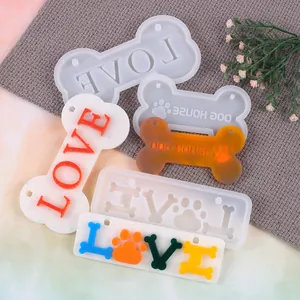 Detail view of DIY bone-shaped silicone molds and finished resin pet tags with LOVE