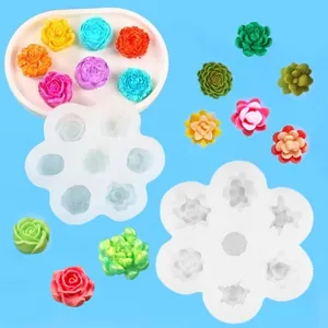 Detalle de moldes de silicona en forma de flor blanca con varios productos florales acabados.